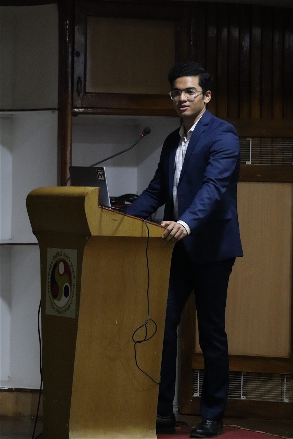 Abhishek Das speaking at a lectern at IIT Guwahati